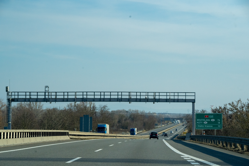 Czech e-vignette enforcement gantry on the D2/E65 motorway heading towards Bratislava, 12 km from the Czech-Slovak border at Lanžhot, with distance signs to Kúty and Státní hranice, captured on February 26, 2026