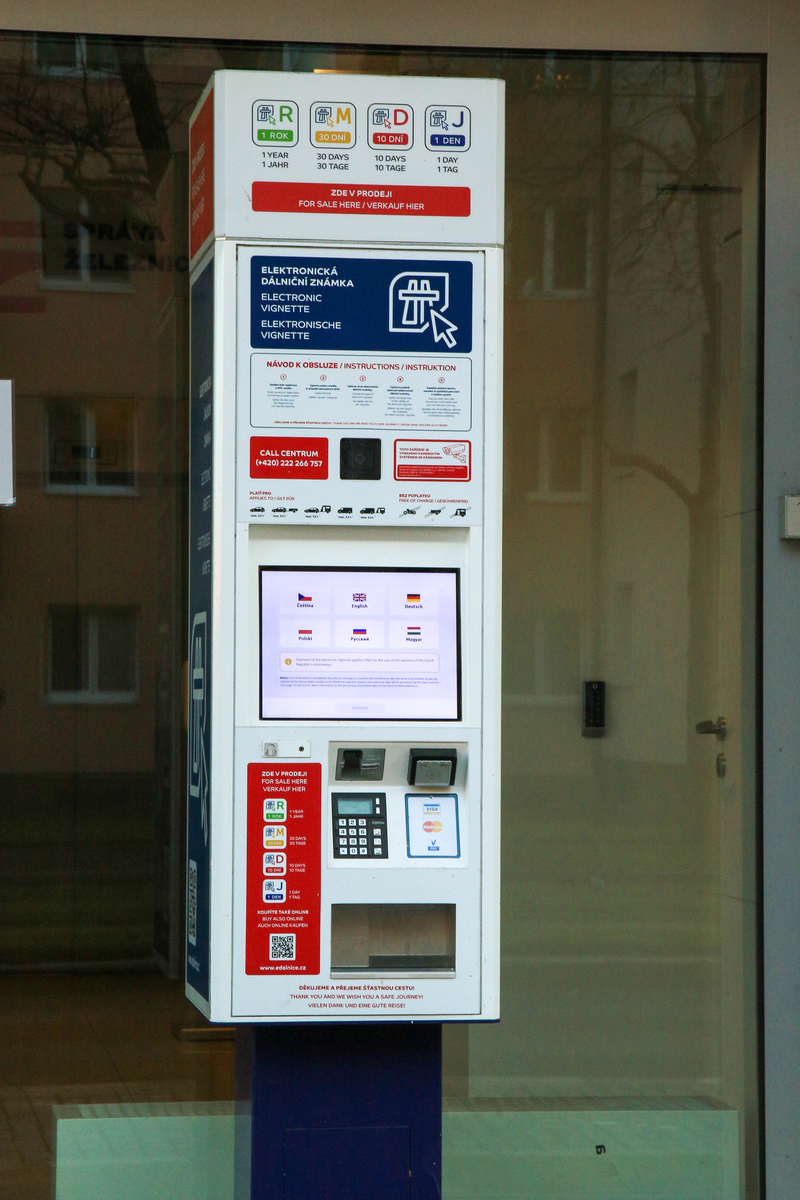 Czech electronic vignette self-service machine at the SFDI building in Prague, showing language selection screen with Czech, English, German, Polish, Russian and Hungarian options, and all vignette types from 1 day to 1 year